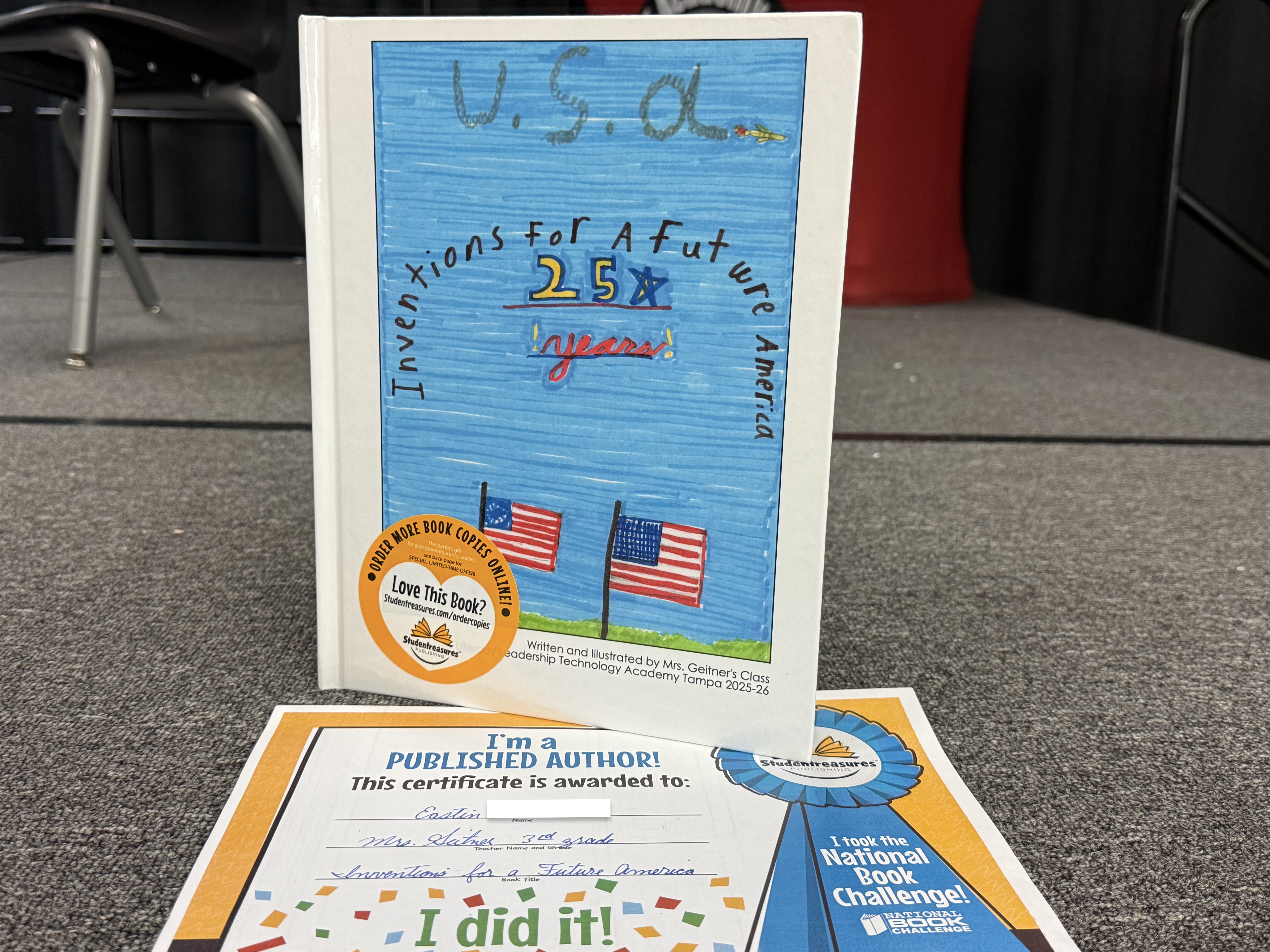 A book with a blue cover on top of a certificate